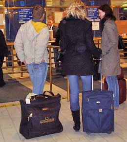 Comfortable travelers with their roller bags wait at the dock, Stockholm, Sweden.