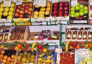 A small market in Paris displaying the fruits outside.