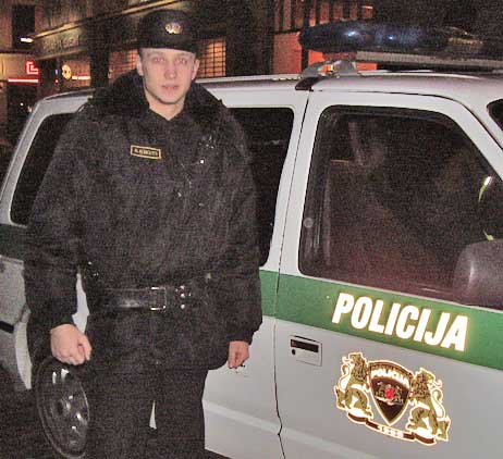 A policeman standing next to his car in Riga, Latvia.