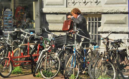 A young fellow on his way to work in Amsterdam parks his bike.