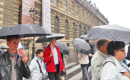 Tourists leave a Paris museum in a drizzle.